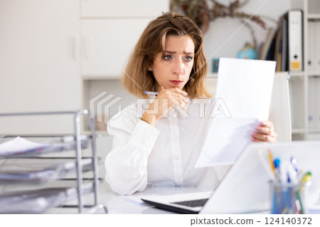 Tired businesswoman working with documents in office at table 124140372