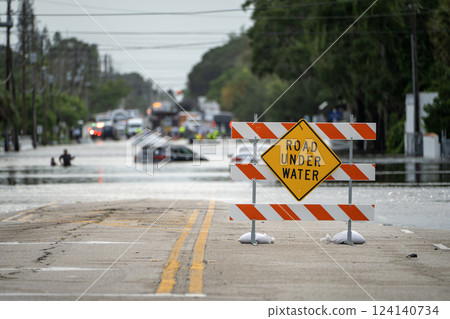 Hurricane Debby flooded street with road closed sign blocking driving of cars in Sarasota, Florida. Safety of transportation during natural disaster concept 124140734