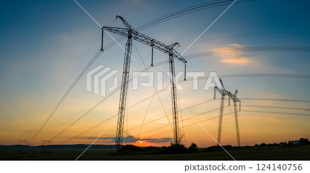 High voltage towers with electric power lines at sunset 124140756