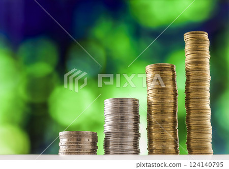 Growing coins stacks with green and blue sparkling bokeh background. Financial growth, saving money, business finance wealth and success concept. 124140795