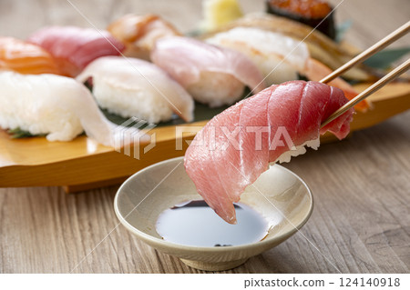 Pick up delicious looking sushi on a plate with chopsticks Pick up delicious looking sushi on a plate with chopsticks 124140918