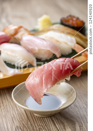 Pick up delicious looking sushi on a plate with chopsticks Pick up delicious looking sushi on a plate with chopsticks 124140920