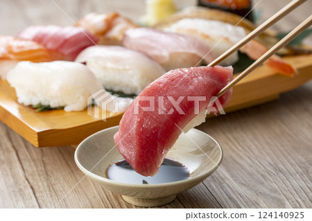用筷子夾起盤子裡美味的壽司 用筷子夾起盤子裡美味的壽司 124140925