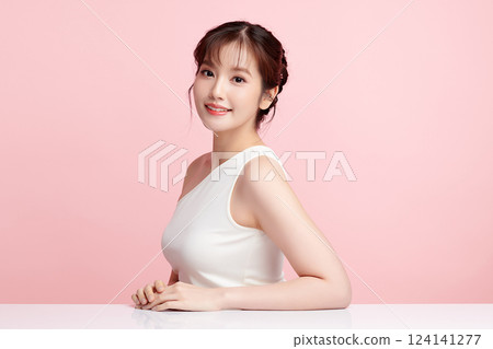 A beautiful young Asian woman with clean, fresh skin against a pink background. Skincare, facial treatment, cosmetology, beauty, and spa. An elegant portrait of an Asian woman. A beautiful young Asian woman with clean, fresh skin against a pink background. Skincare, facial treatment, cosmetology, beauty, and spa. An elegant portrait of an Asian woman. 124141277