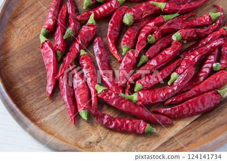 Red chili peppers on a wooden plate Red chili peppers on a wooden plate 124141734
