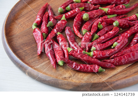 Red chili peppers on a wooden plate Red chili peppers on a wooden plate 124141739