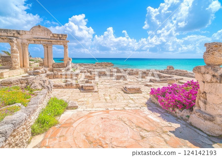 Historic ruins by the beach with vibrant flowers under a bright sky Historic ruins by the beach with vibrant flowers under a bright sky 124142193