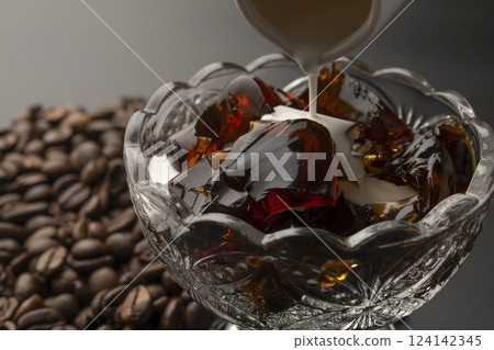 Cold coffee jelly served in a glass bowl with milk poured over it Coffee beans Cold coffee jelly served in a glass bowl with milk poured over it Coffee beans 124142345