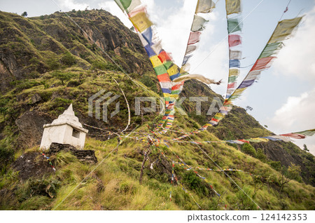 Prayer flags blowing by the wind on the small hill in Syabrubesi village a beautiful resident village inside the Langtang National Park of Nepal. Prayer flags blowing by the wind on the small hill in Syabrubesi village a beautiful resident village inside the Langtang National Park of Nepal. 124142353