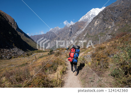 Porter carrying guest bags in Langtang valley, Nepal. Porter carrying guest bags in Langtang valley, Nepal. 124142360