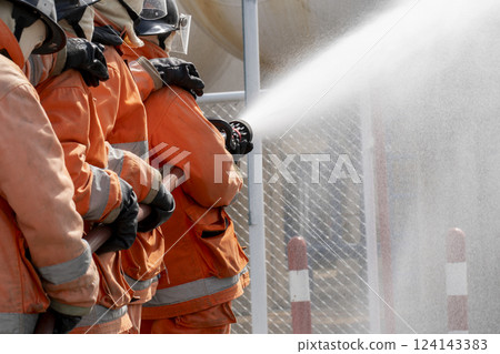 fire fighter is controlling a fire 124143383