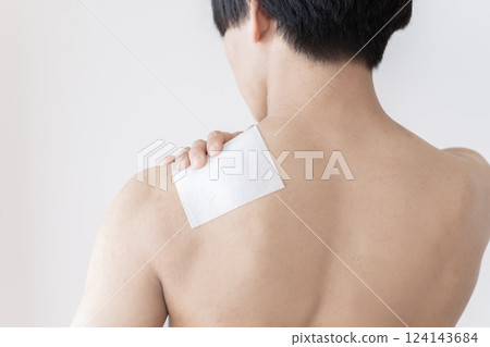 Man applying a compress to his shoulder, shoulder pain, stiff shoulders, compress, muscle pain 124143684