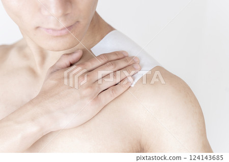 Man applying a compress to his shoulder, shoulder pain, stiff shoulders, compress, muscle pain Man applying a compress to his shoulder, shoulder pain, stiff shoulders, compress, muscle pain 124143685
