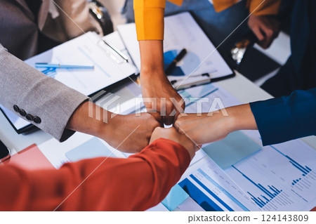 Businessmen and businesswomen joining hands in group meeting at multicultural office room showing teamwork, support and unity in business. Diversity workplace 124143809