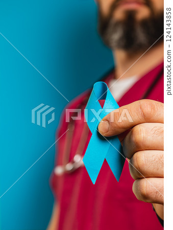 Healthcare professional holding a blue ribbon in a clinic setting Healthcare professional holding a blue ribbon in a clinic setting 124143858