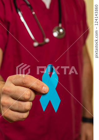 Health professional holding a blue ribbon symbolizing awareness in clinic Health professional holding a blue ribbon symbolizing awareness in clinic 124143860
