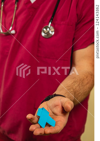 Medical professional showcases blue ribbon symbolizing health awareness Medical professional showcases blue ribbon symbolizing health awareness 124143862