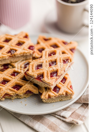 Sweet linzer cake on plate on kitchen table. 124144090