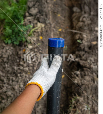 Pipe contractor install new HDPE pipes under the ground in village, 124144189