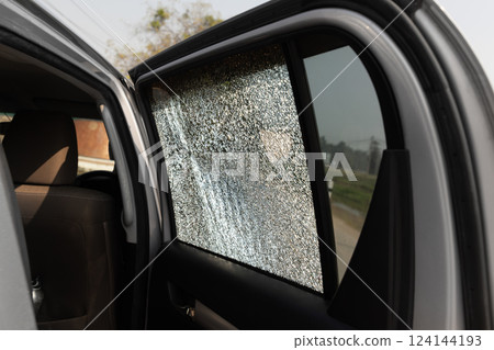 Cracked side car window glass on road . Damaged car window. Car accident claims via insurance apps. Cracked side car window glass on road . Damaged car window. Car accident claims via insurance apps. 124144193
