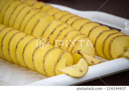 Spiral-cut potatoes on a white platter create an artistic presentation of this versatile vegetable. 124144437