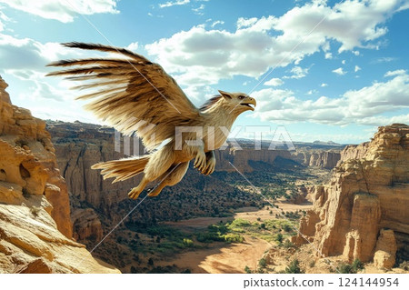 Majestic eagle soaring over a dramatic landscape with mountains and clouds 124144954