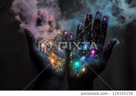 Hands filled with colorful sparkles and swirling smoke create an enchanting visual effect in a dark setting 124145258
