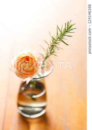 Beautiful pinkish coral orange roses under sunlight in on wooden table. Floral natural background with rose flower. 124146166