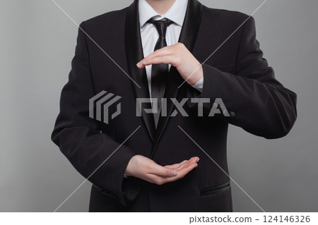 Businessman in black suit holding hands in the shape of the Earth. Concept of worldwide business Businessman in black suit holding hands in the shape of the Earth. Concept of worldwide business 124146326