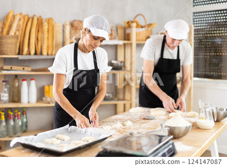 Elderly man and woman make and fold pieces of dough 124147087