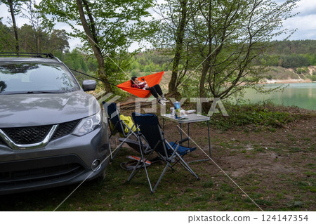 Serene Camping Setup with Hammock and Car Serene Camping Setup with Hammock and Car 124147354
