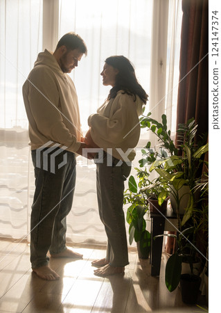 Intimate Moment of Expecting Parents by the Window 124147374