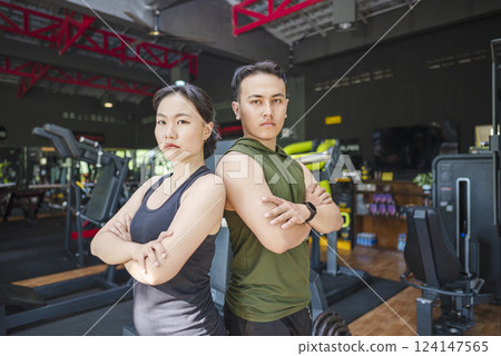 Chinese east asian woman and indonesian southeast asian man working out together at the gym. Fitness exercise and healthy lifestyle concept 124147565