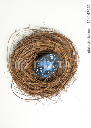 Top view of nest filled with colorful decorated easter egg. Concept of celebrating the easter holiday 124147662