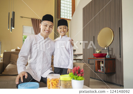 Portrait of the Indonesian Muslim father with his son celebrating Eid Mubarak. Concept of Happy Lebaran, Eid Al Fitr, Idul Fitri, and Ramadan Mubarak celebration 124148092