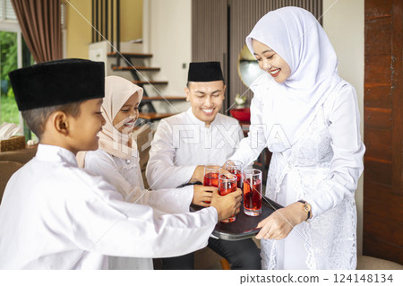 Portrait of the Indonesian Muslim mother serving a drink for the whole family while celebrating Eid Mubarak. Concept of Happy Lebaran, Eid Al Fitr, Idul Fitri, and Ramadan Mubarak celebration Portrait of the Indonesian Muslim mother serving a drink for the whole family while celebrating Eid Mubarak. Concept of Happy Lebaran, Eid Al Fitr, Idul Fitri, and Ramadan Mubarak celebration 124148134