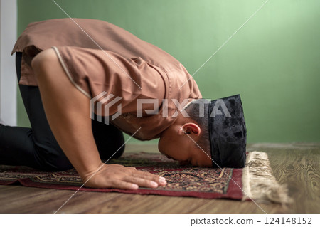 Portrait of an Indonesian muslim man praying (salat) at home. Concept of Islamic praying or Ramadan Kareem 124148152