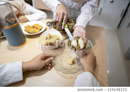 Indonesian Muslim wife serving ketupat rice dumpling for family in the house. Traditional Muslim food during the celebration of Happy Lebaran, Eid Al Fitr, Idul Fitri, and Ramadan Mubarak celebration Indonesian Muslim wife serving ketupat rice dumpling for family in the house. Traditional Muslim food during the celebration of Happy Lebaran, Eid Al Fitr, Idul Fitri, and Ramadan Mubarak celebration 124148153