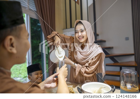 Portrait of Indonesian Muslim mother preparing food for iftar to her family at home. Concept of Happy Lebaran, Eid Al Fitr, Idul Fitri, and Ramadan Mubarak celebration 124148166