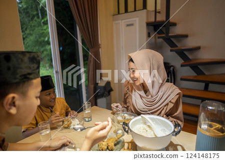 Portrait of Indonesian Muslim family breaking their fasting together at home. Concept of Happy Lebaran, Eid Al Fitr, Idul Fitri, and Ramadan Mubarak celebration Portrait of Indonesian Muslim family breaking their fasting together at home. Concept of Happy Lebaran, Eid Al Fitr, Idul Fitri, and Ramadan Mubarak celebration 124148175