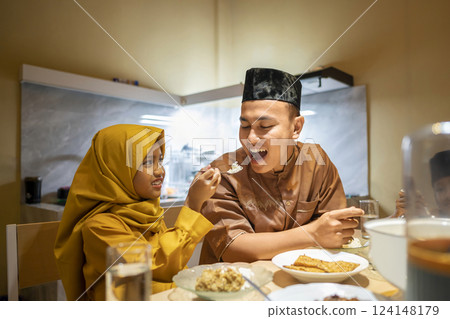 Portrait of Indonesian Muslim family breaking their fasting together at home. Concept of Happy Lebaran, Eid Al Fitr, Idul Fitri, and Ramadan Mubarak celebration 124148179