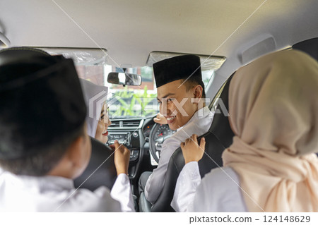 An Indonesian Muslim family is going mudik or traveling to their hometown by car. Concept of Happy Lebaran, Eid Al Fitr, Idul Fitri, and Ramadan Mubarak celebration 124148629