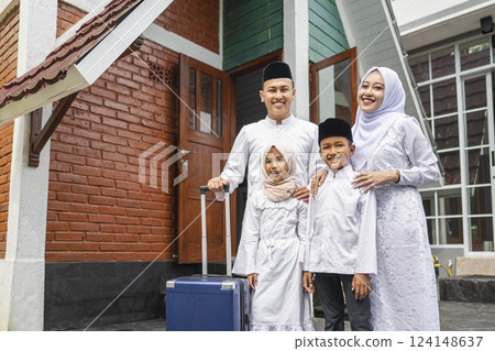 An Indonesian Muslim family with a suitcase arrives in their hometown. Mudik or traveling to their hometown. Concept of Happy Lebaran, Eid Al Fitr, Idul Fitri, and Ramadan Mubarak celebration An Indonesian Muslim family with a suitcase arrives in their hometown. Mudik or traveling to their hometown. Concept of Happy Lebaran, Eid Al Fitr, Idul Fitri, and Ramadan Mubarak celebration 124148637