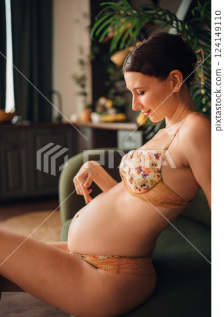 Young pregnant woman relaxing on a couch in a cozy indoor setting 124149110