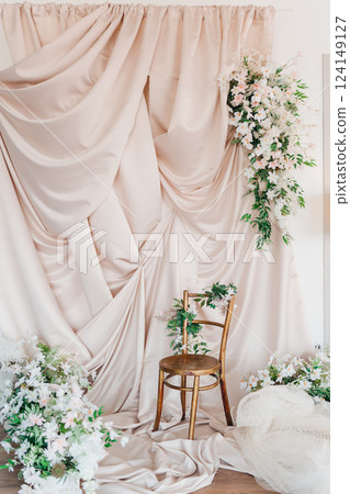Elegant floral backdrop with golden chair for a special occasion setup Elegant floral backdrop with golden chair for a special occasion setup 124149127