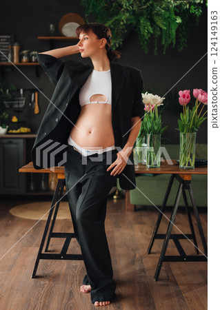 Pregnant young woman posing in stylish outfit at home 124149163