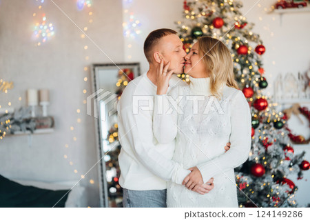 happy man and woman in a room with a Christmas tree.  124149286