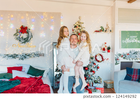 Father and daughters at the Christmas tree. Father and daughters at the Christmas tree. 124149292