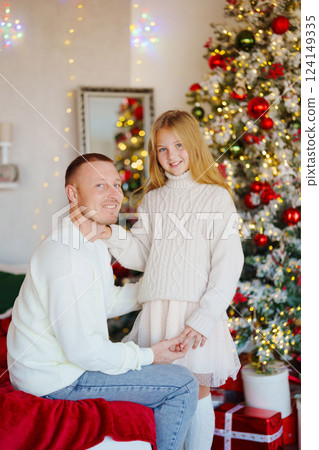 Father and teenage daughter at the Christmas tree.  Father and teenage daughter at the Christmas tree.  124149335