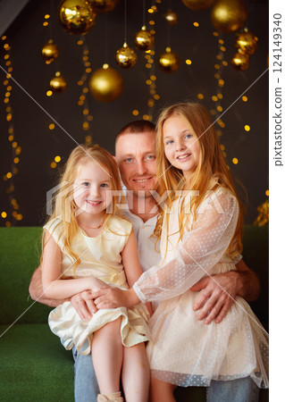 Father and daughters at the Christmas tree.  124149340